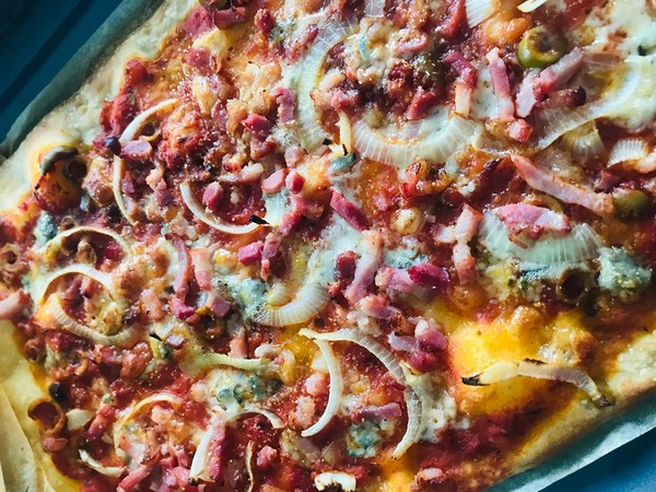 Pizza met spekjes, blauwe kaas en uien